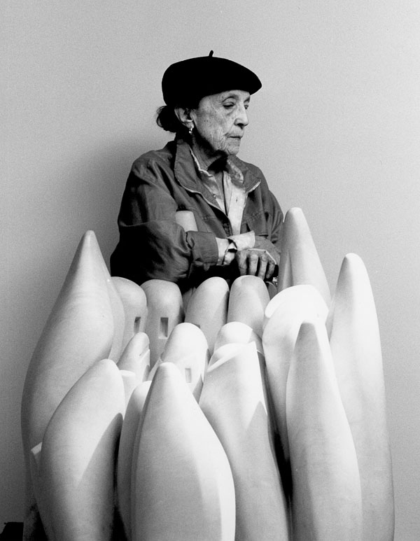 Louise Bourgeois in 1990, behind her marble sculpture Eye to Eye, 1970