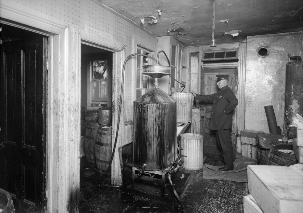 A police officer inspecting stills for bootleg liquor in Brooklyn (July 1927) (courtesy New York City Municipal Archives)