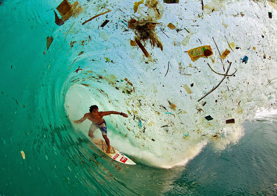 A surfer riding a wave of rubbish near Java in Indonesia, the world's most populous island.