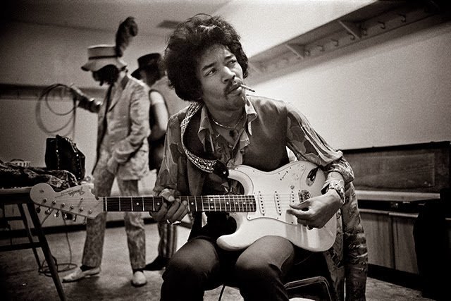 jimi hendrix playing guitar smoking