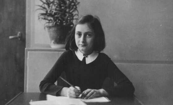 Anne Frank, age twelve, at her school desk. 