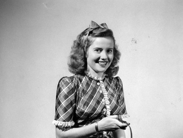 Actress Joyce Reynolds holding shutter release to take her own photograph.